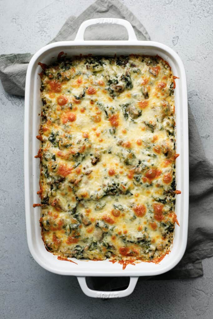 Spinach Fandango is a hearty casserole of cheese, spinach, beef and rice in a large casserole dish.
