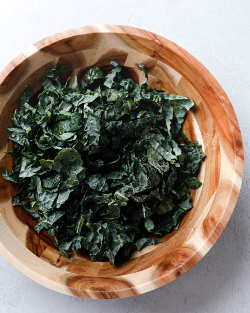 A wooden bowl filled with Lacinato Kale