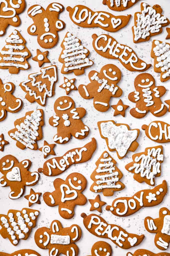 Overhead image of a variety of gingerbread cookies decorated with white royal icing