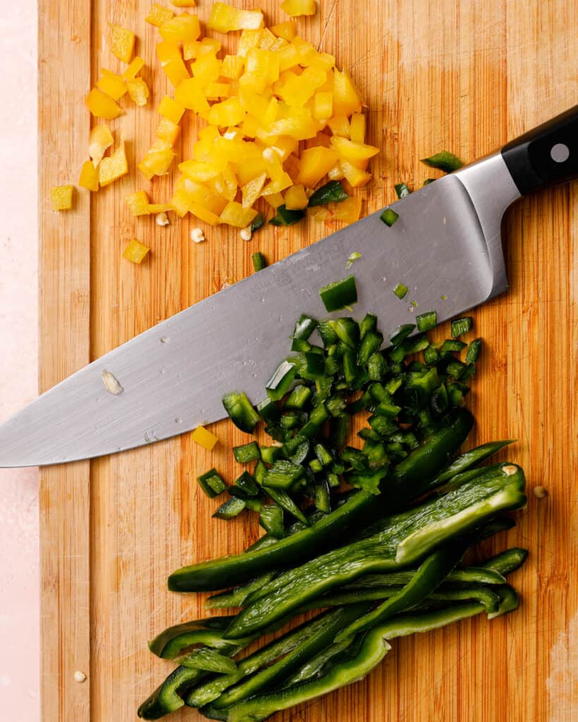Diced poblano and yellow bell pepper on a cutting board