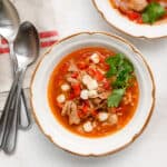 overhead image of bowls of red posole with pork and hominy