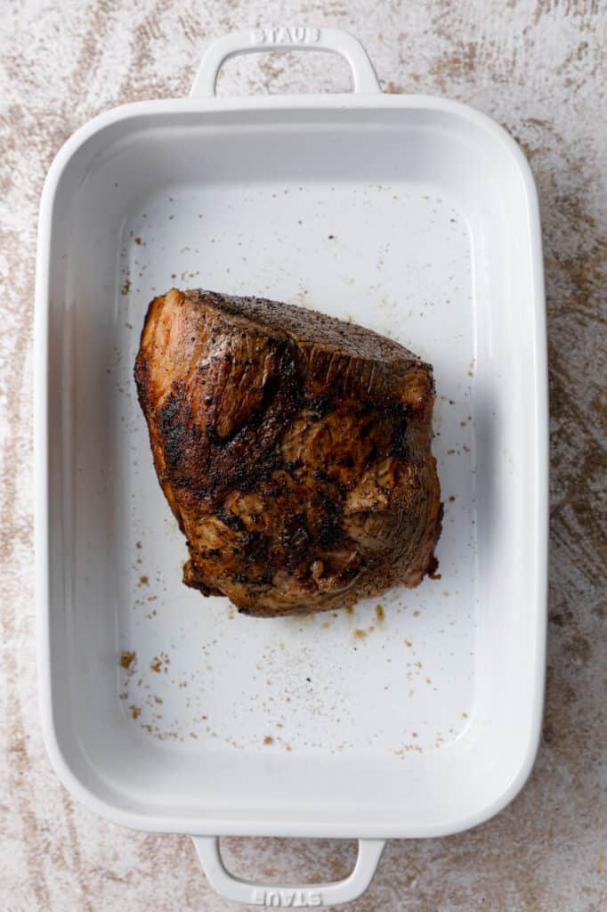 overhead view of a seared piece of beef in a baking pan
