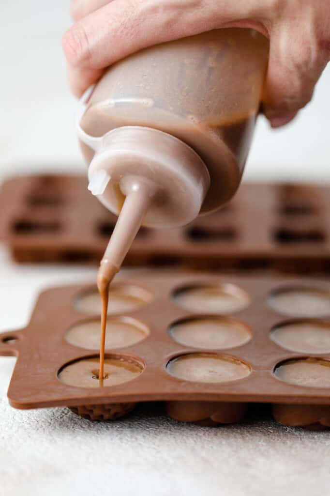 a squeeze bottle adding chocolate to a mould