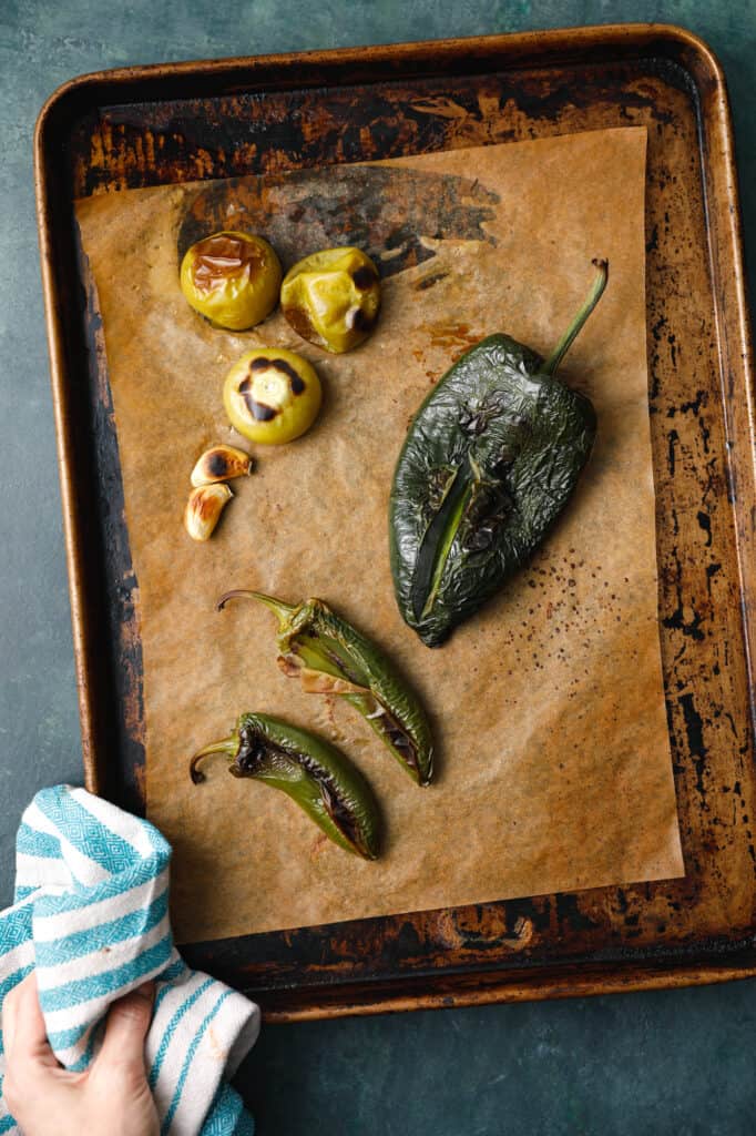 overhead of a sheet pan from the oven with roasted vegetables on it to make salsa