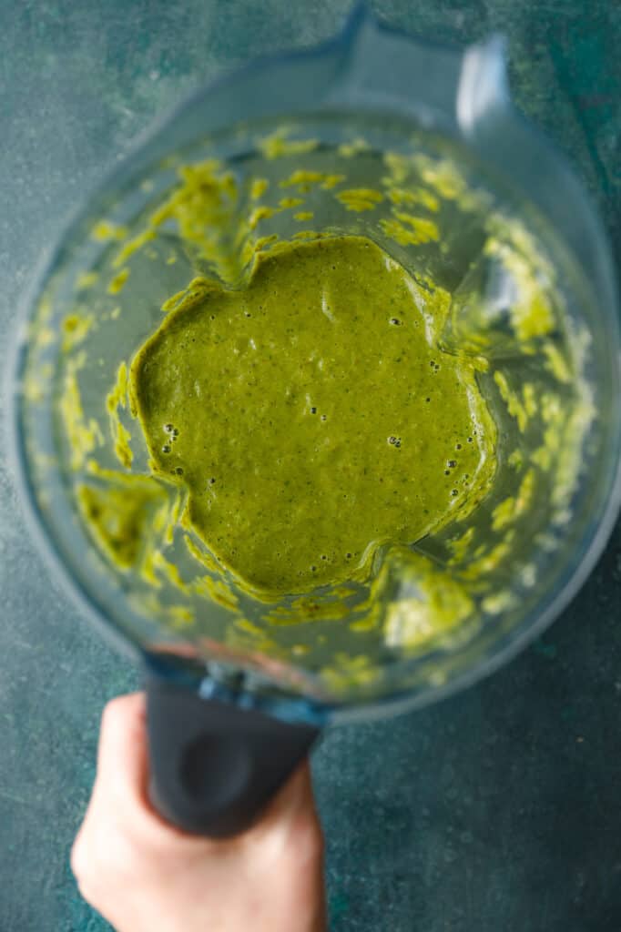 overhead shot looking into a blender with the ingredients blended together for a bright green salsa