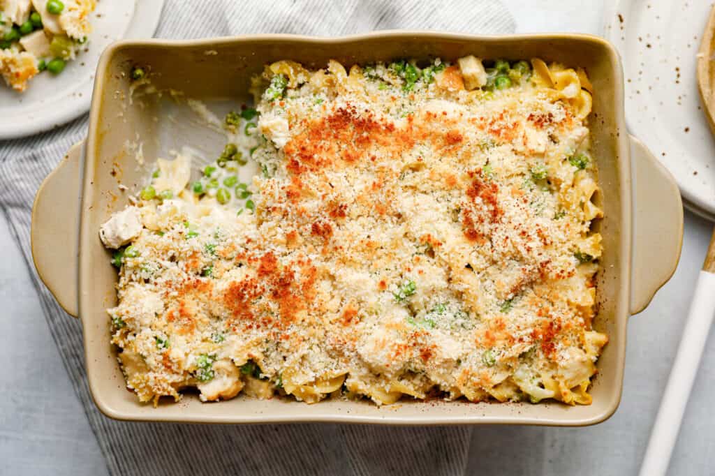 Uma caçarola de Chicken Noodle Casserole com ervilhas e uma cobertura de panko crocante