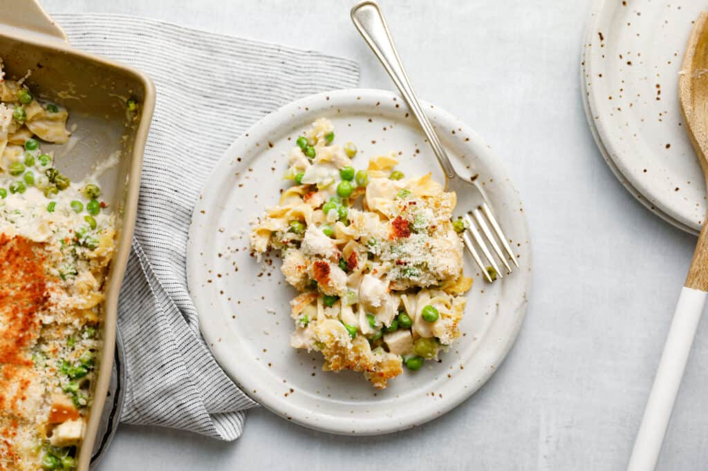 Une portion de casserole de nouilles au poulet crémeuse sur une assiette à dîner avec une fourchette