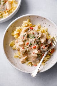 a bowl filled with Chicken a la King, creamy sauce with peppers and mushrooms over noodles