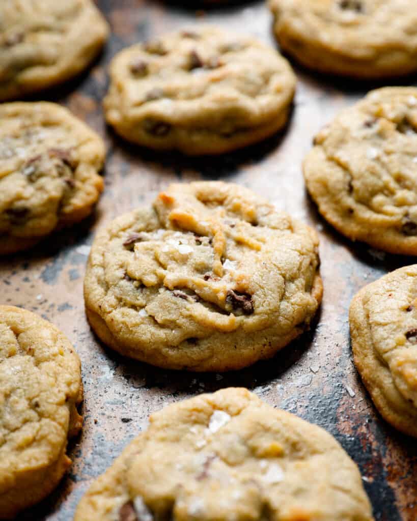 image of a close up of a chocolate chip cookie with flake salt on a cookie sheet