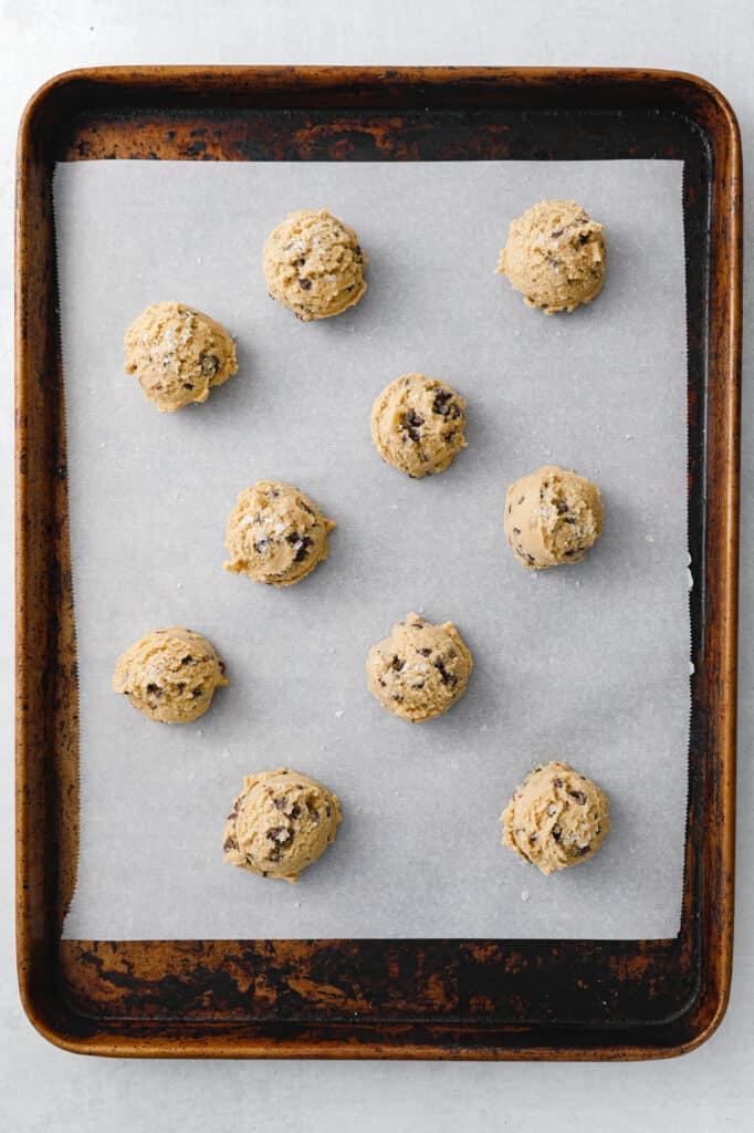 chocolate chip cookie dough scooped on to a baking sheet in small rounds