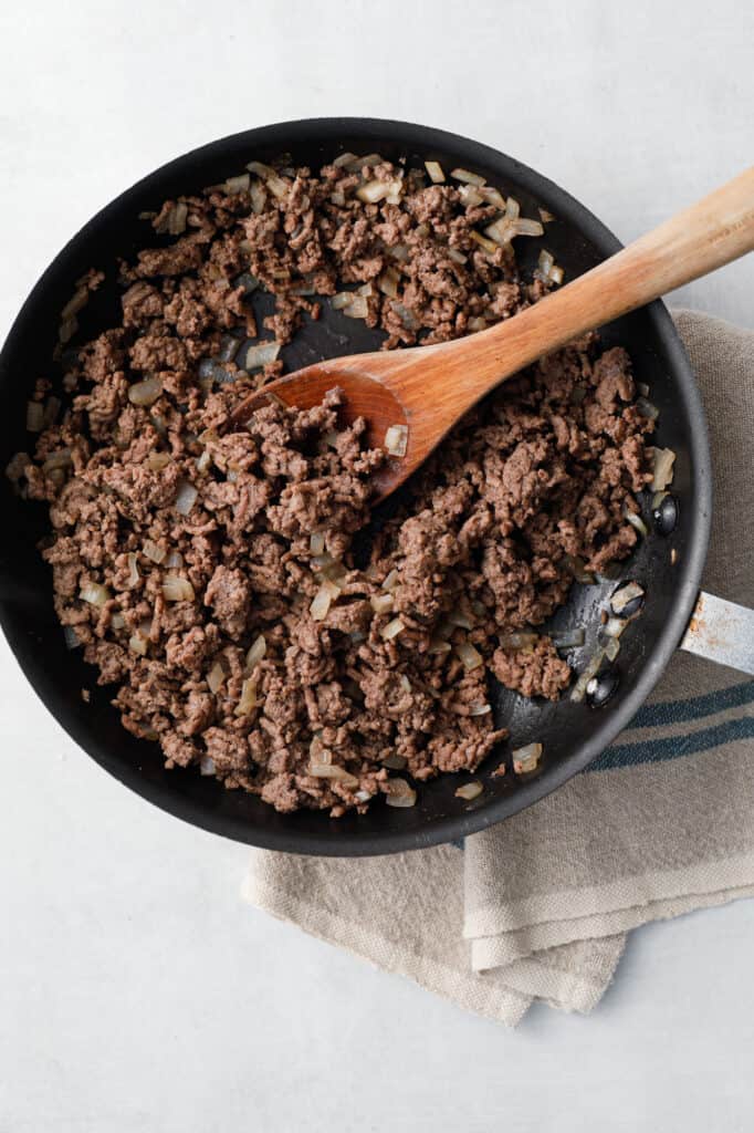 overhead view of a pan of browned ground beef and onions as a part of the recipe process