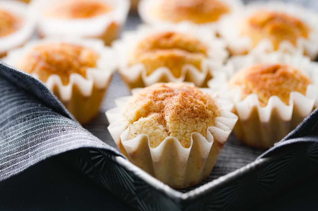 sweet cake snickerdoodle muffins are topped with cinnamon and sugar in cute cupcake liners