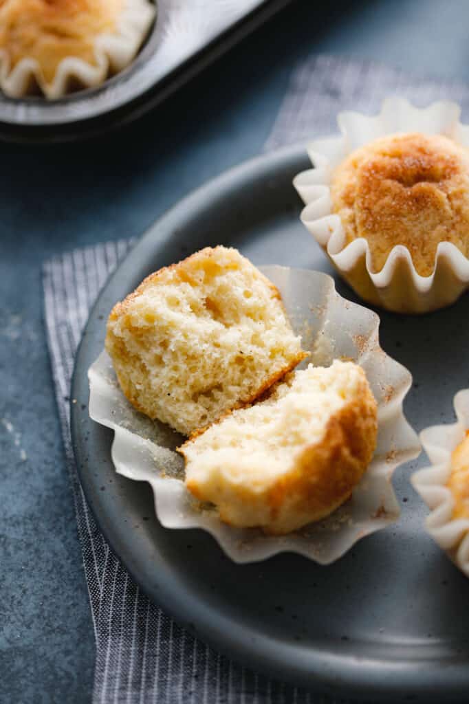 snickerdoodle muffins cut in half to show the soft cake-like interior