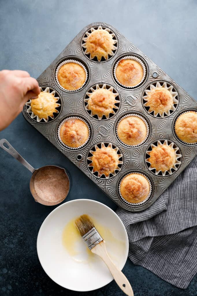 snickerdoodle muffins out of the oven ready to be sugared