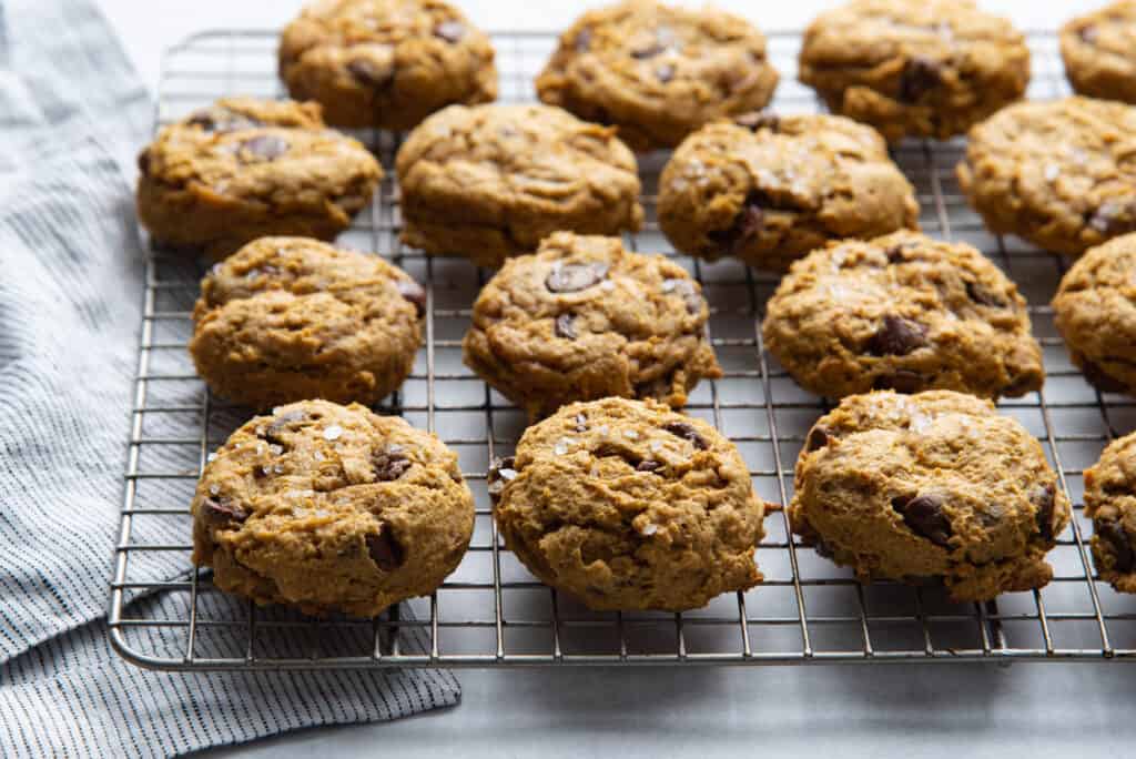 soft baked chocolate chip pumpkin cookies on a cooling rack fresh out of the oven