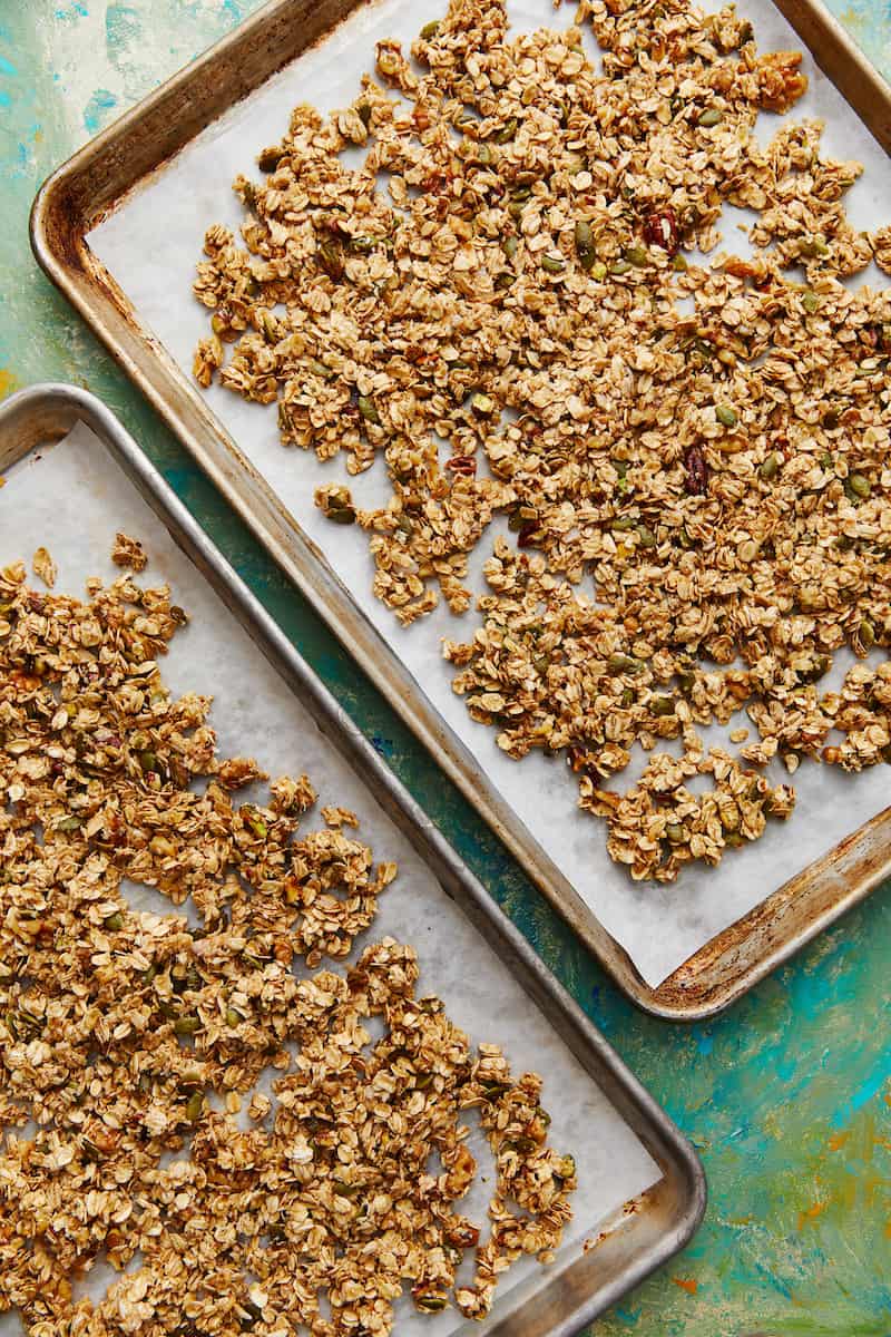 sheet pans with granola spread on them for baking