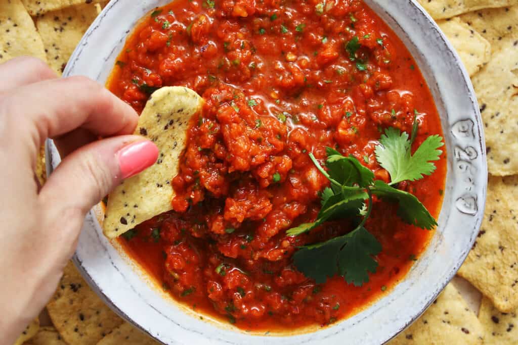 fresh homemade salsa being dipped with a chip