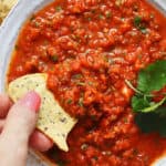 fresh homemade salsa being dipped with a chip