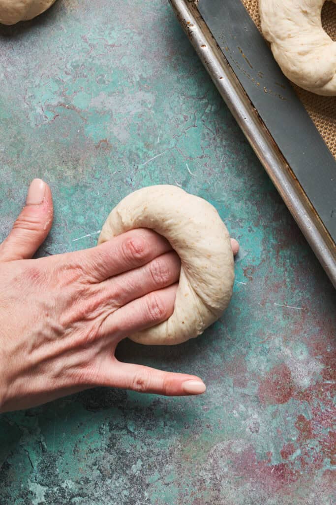 hands rolling bagel dough into a round