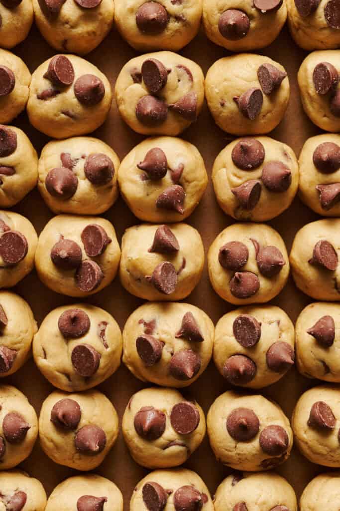 chocolate chip cookie dough balls topped with more chocolate chips before they're baked
