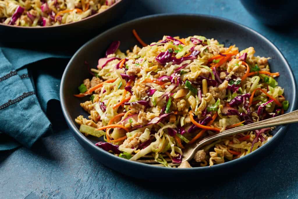 overhead view of a bowl of chicken salad with cabbage and carrots