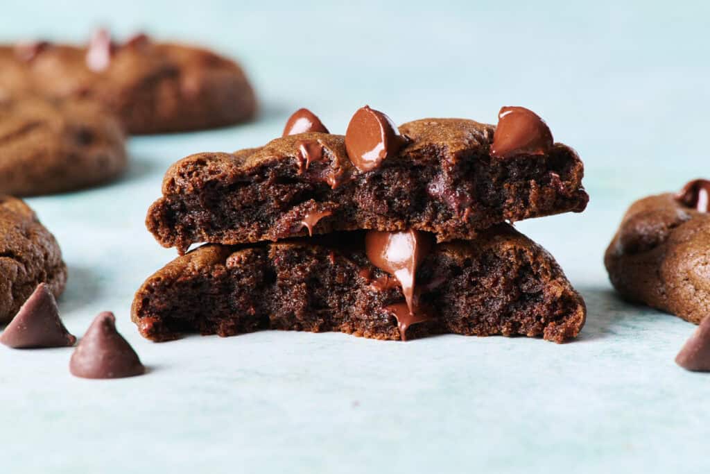 Closeup of a double chocolate chip cookie cut in half with glossy melty chocolate