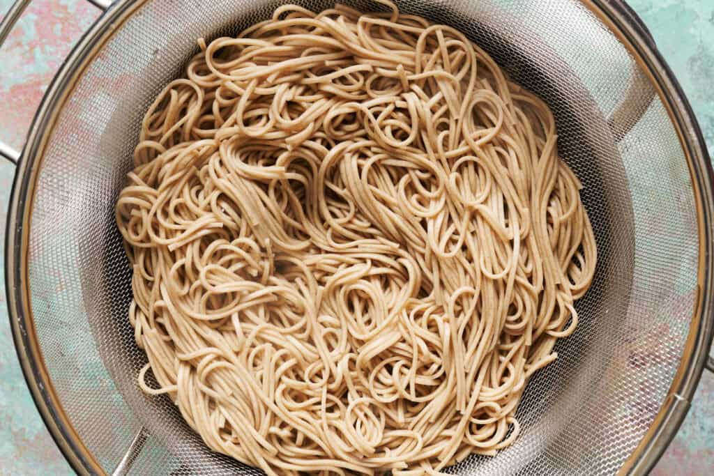 overhead view of cooked noodles in a strainer