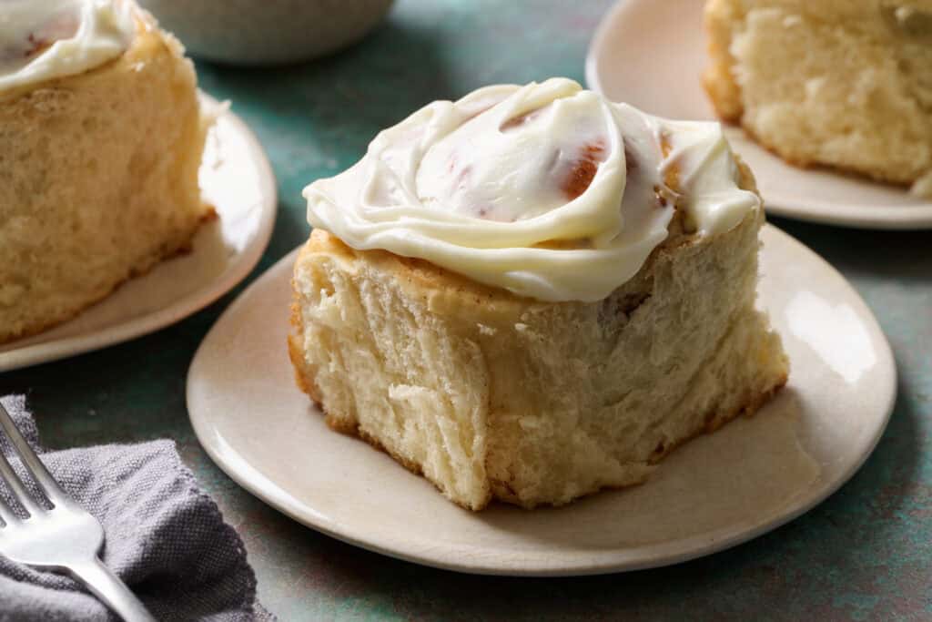 a cinnamon roll on a plate ready to be eaten