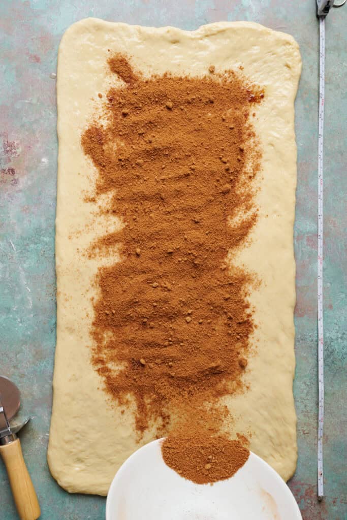 spreading cinnamon and sugar onto rolled out dough