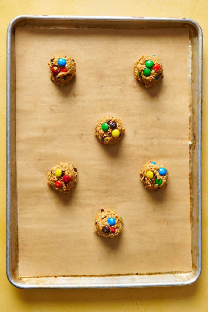 uncooked monster cookie dough balls on a sheet tray before baking