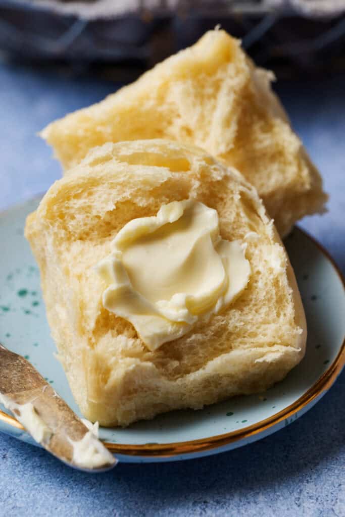 a sourdough discard dinner roll smeared with butter