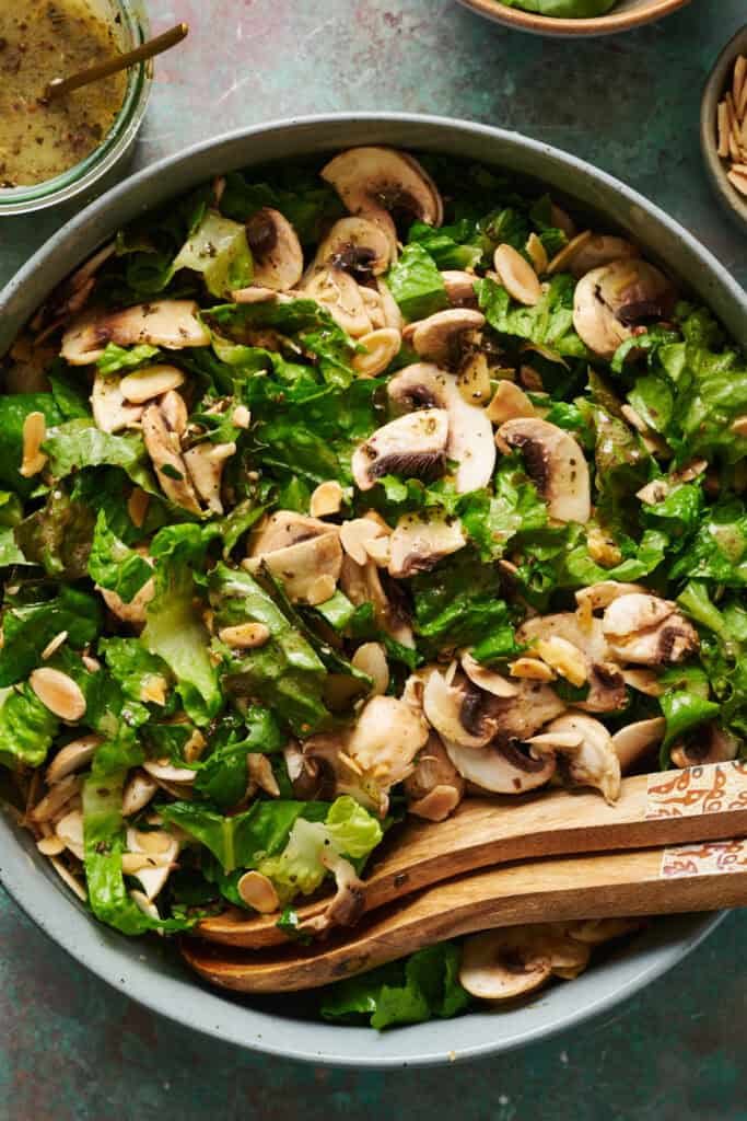 Overhead of salad tossed with wooden tongs