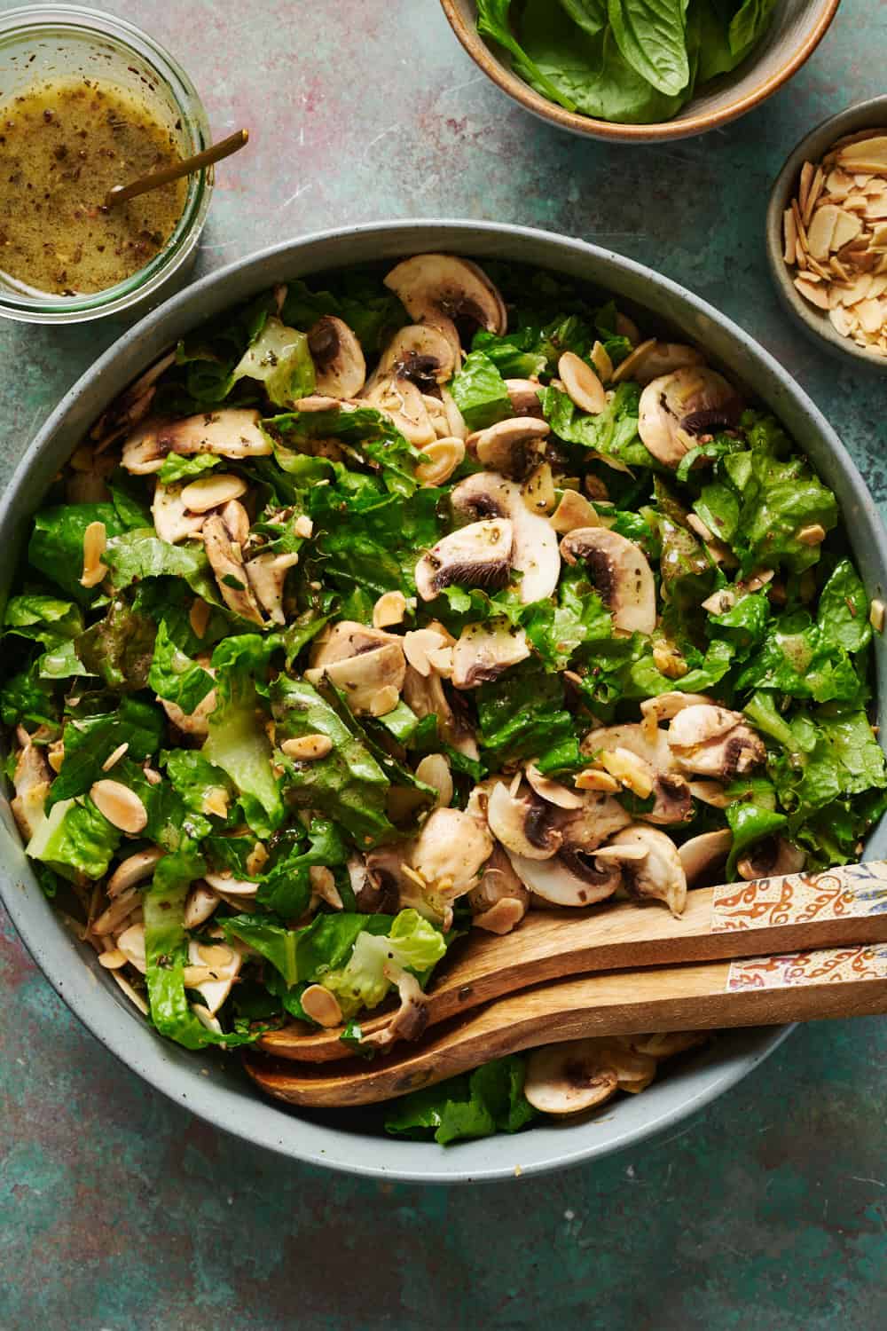 overhead photo of green salad with mushrooms, almonds and scallions