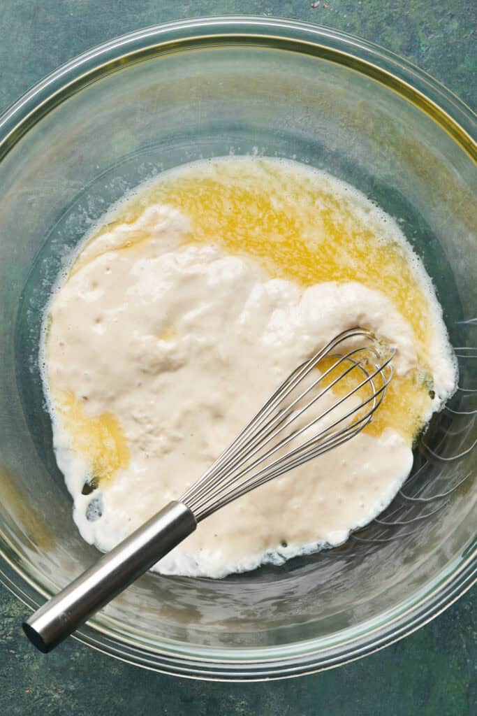 sourdough discard in a bowl with melted butter and a whisk