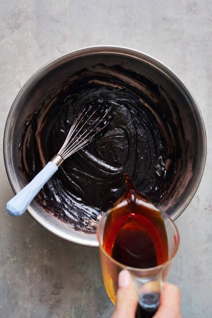 pouring hot coffee into batter to make it rich