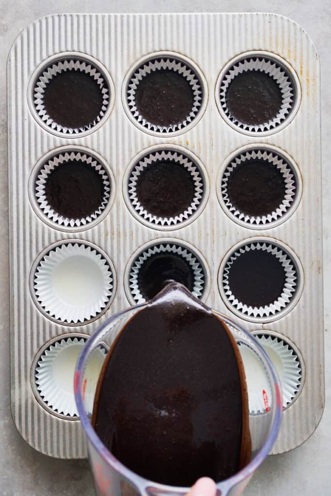 pouring batter into a cupcake tin for black cupcakes