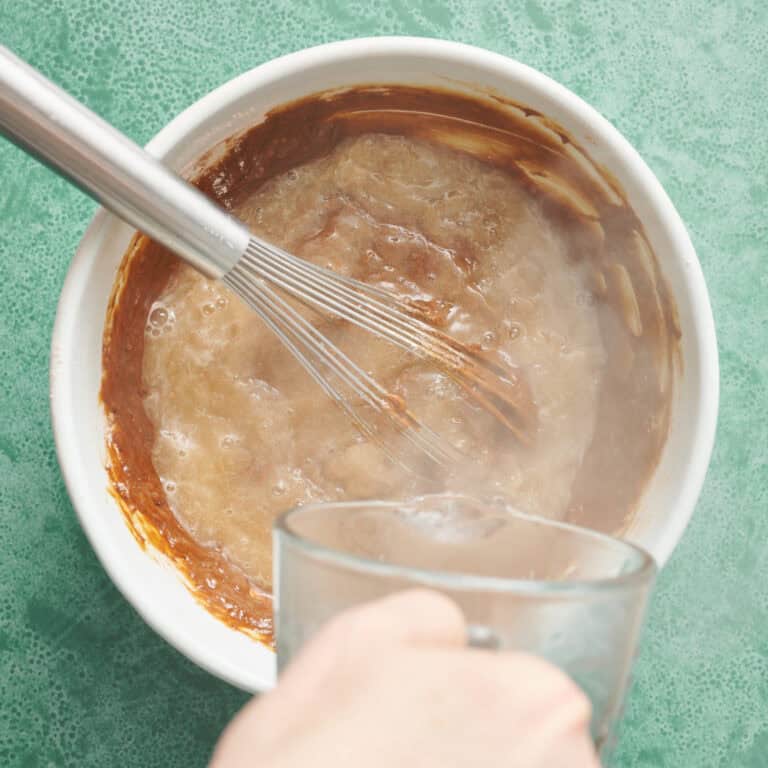 adding hot water to the gingerbread cake