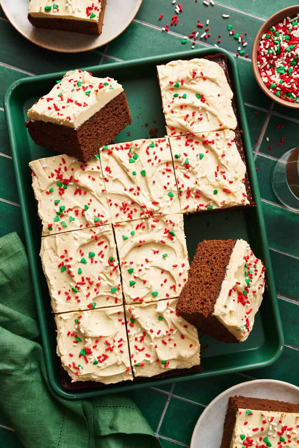 a gingerbread cake with 3 slices removed with red and green sprinkles on top