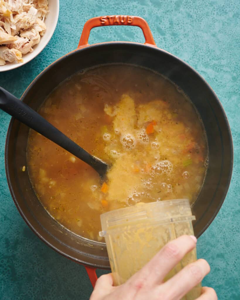 adding blended portion of soup back into the main soup pot for thickening