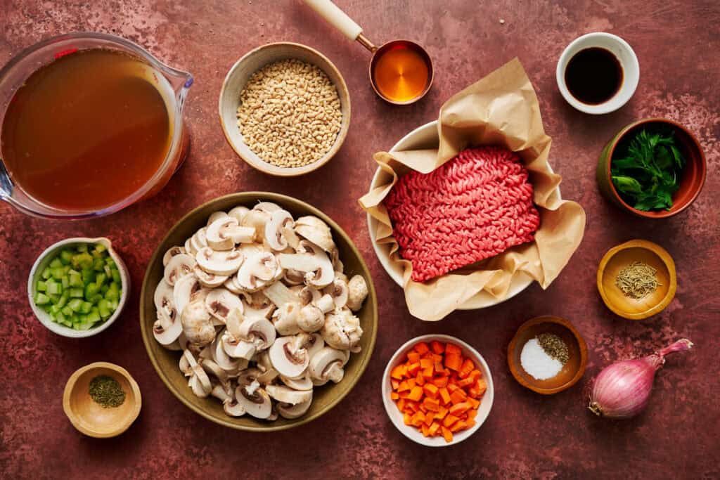 ground beef barley soup recipe ingredients on a red background