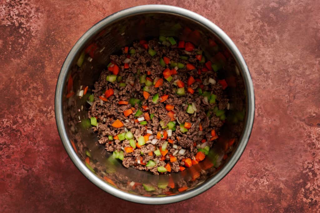 Instant Pot filled with beef, sherry, carrots, celery, and shallot.