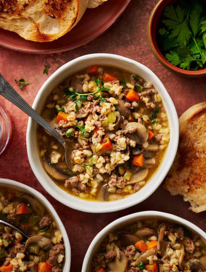 overhead view of a bowl of instant pot ground beef barley soup ready to eat