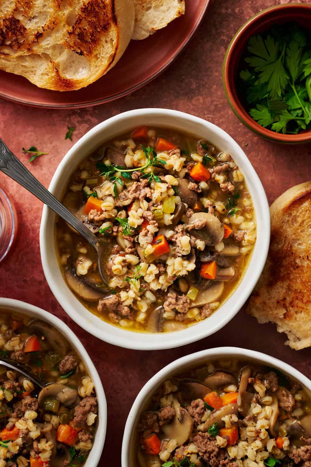 overhead view of a bowl of instant pot ground beef barley soup ready to eat