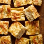 overhead view of slices of sourdough focaccia on a cutting board