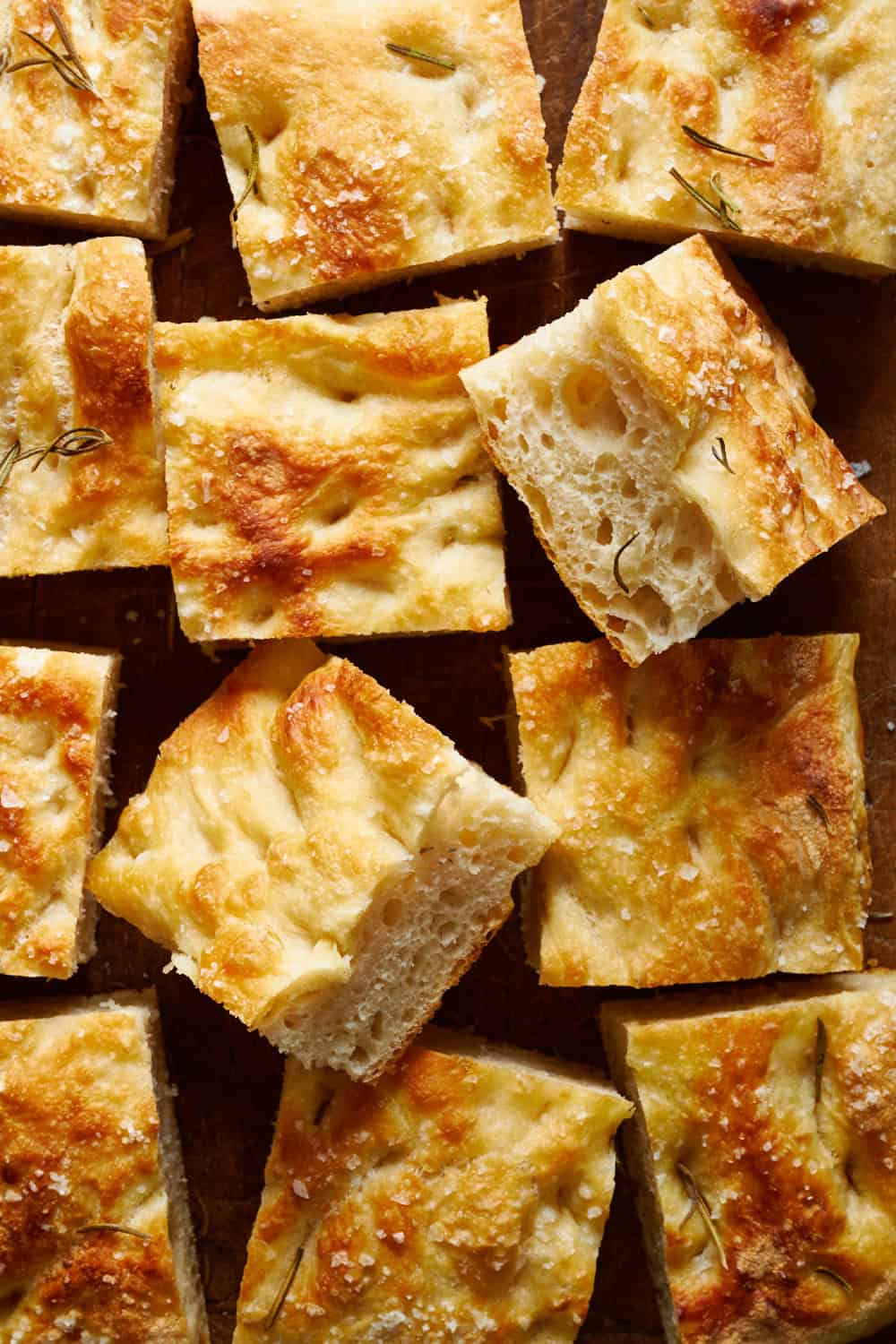 overhead view of sliced sourdough discard focaccia bread on a cutting board