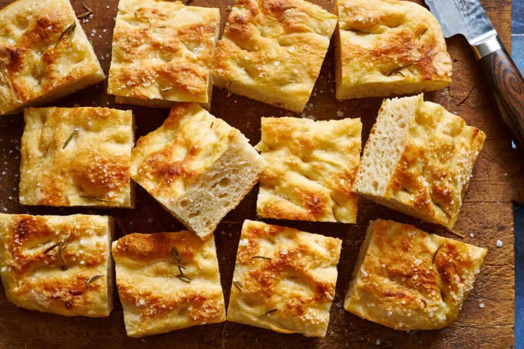 overhead view of a cutting board with sliced sourdough focaccia bread