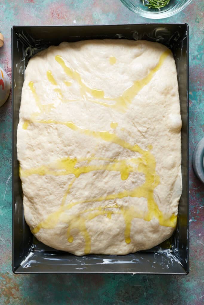 sourdough discard focaccia bread dough in the pan drizzled with olive oil