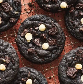 Chocolate Cookies and Cream Cookies on a cooling rack with crumbs sprinkled around.