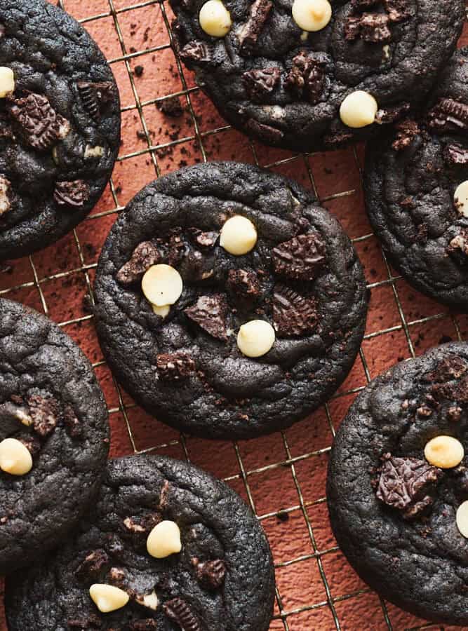 Chocolate Cookies and Cream Cookies on a cooling rack with crumbs sprinkled around.