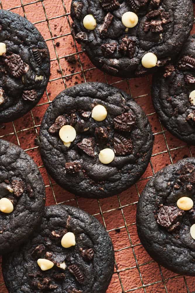 cookies and cream chocolate cookie with white chocolate chips and oreos on a cooling rack